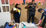 Se observa a los policías con el bebé recién nacido a la mamá en la camilla acostada